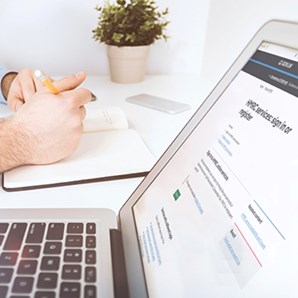 Man taking notes open laptop