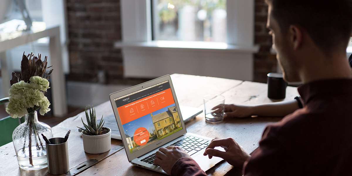 Man looking at Peritus website on laptop